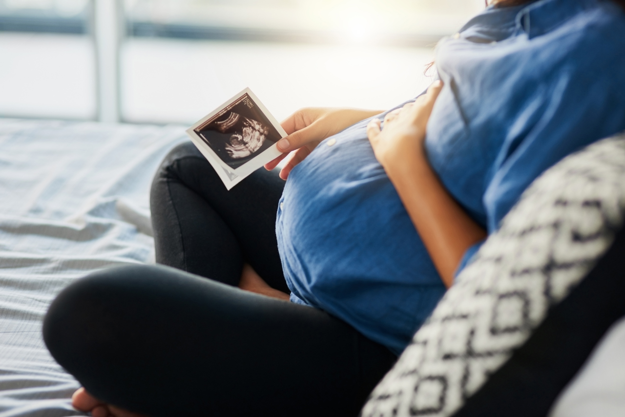 Closeup shot of a pregnant woman holding an ultrasound scan