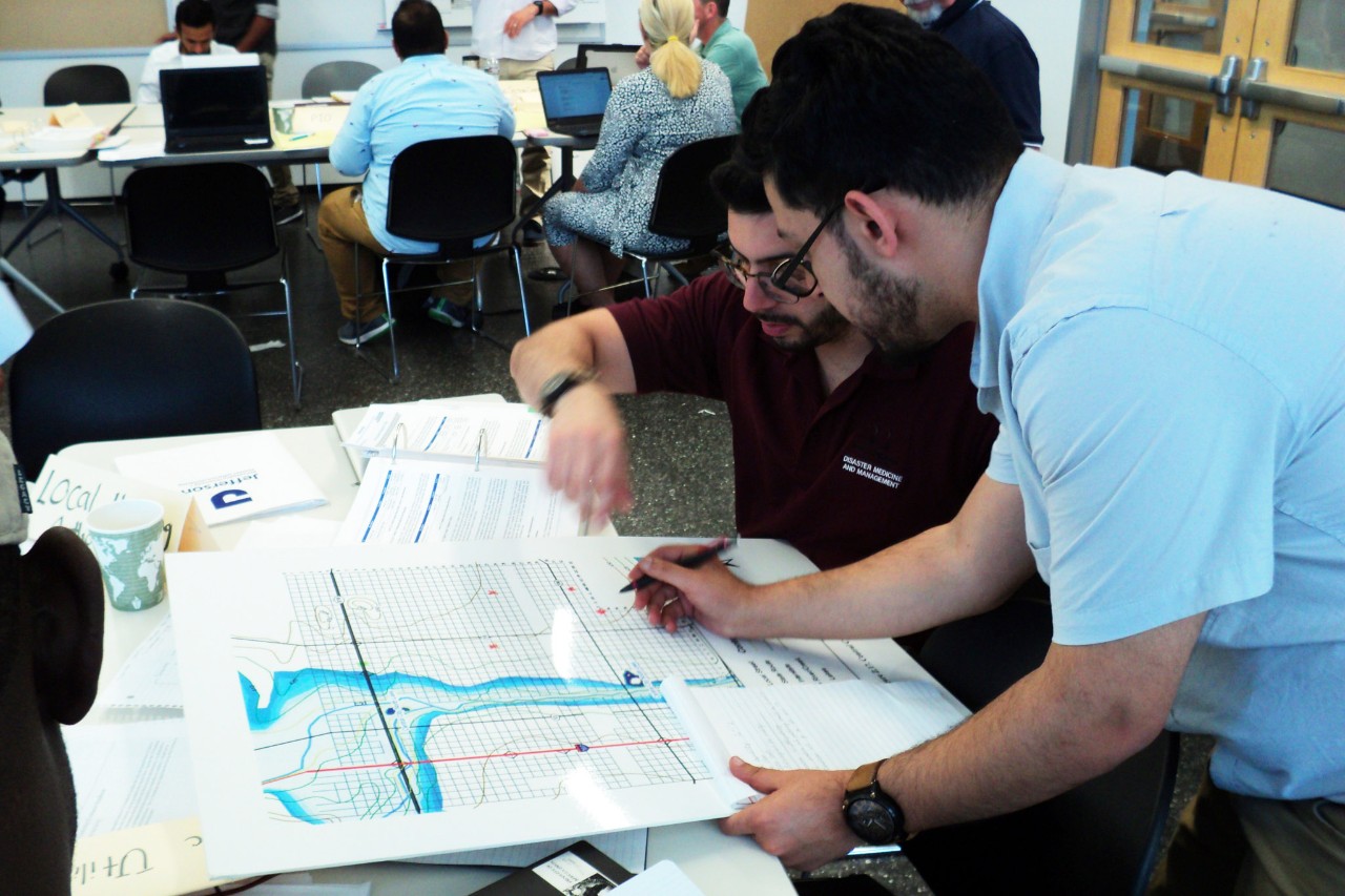 Two students review charts on a desk.