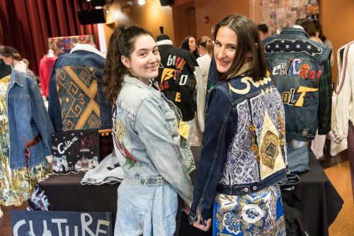 Two student show off the jackets they made.