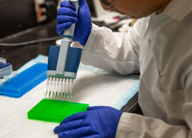 scientist pipeting at the lab bench