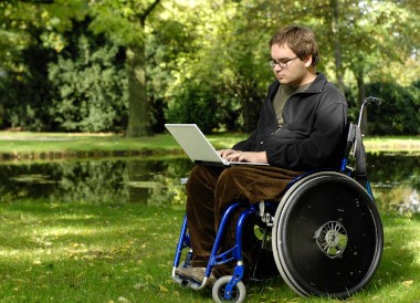 young student learning at the park using his laptop