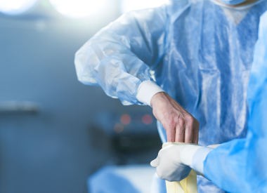 Surgeon is wearing rubber glove. Close up of male and female hands. Copy space in left side