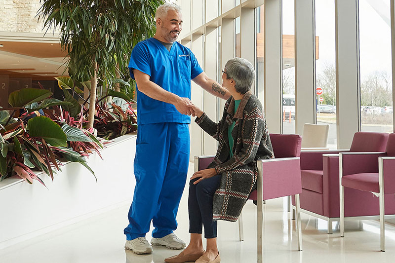 Nurse greeting cancer patient.