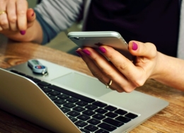 Person using a laptop and a phone