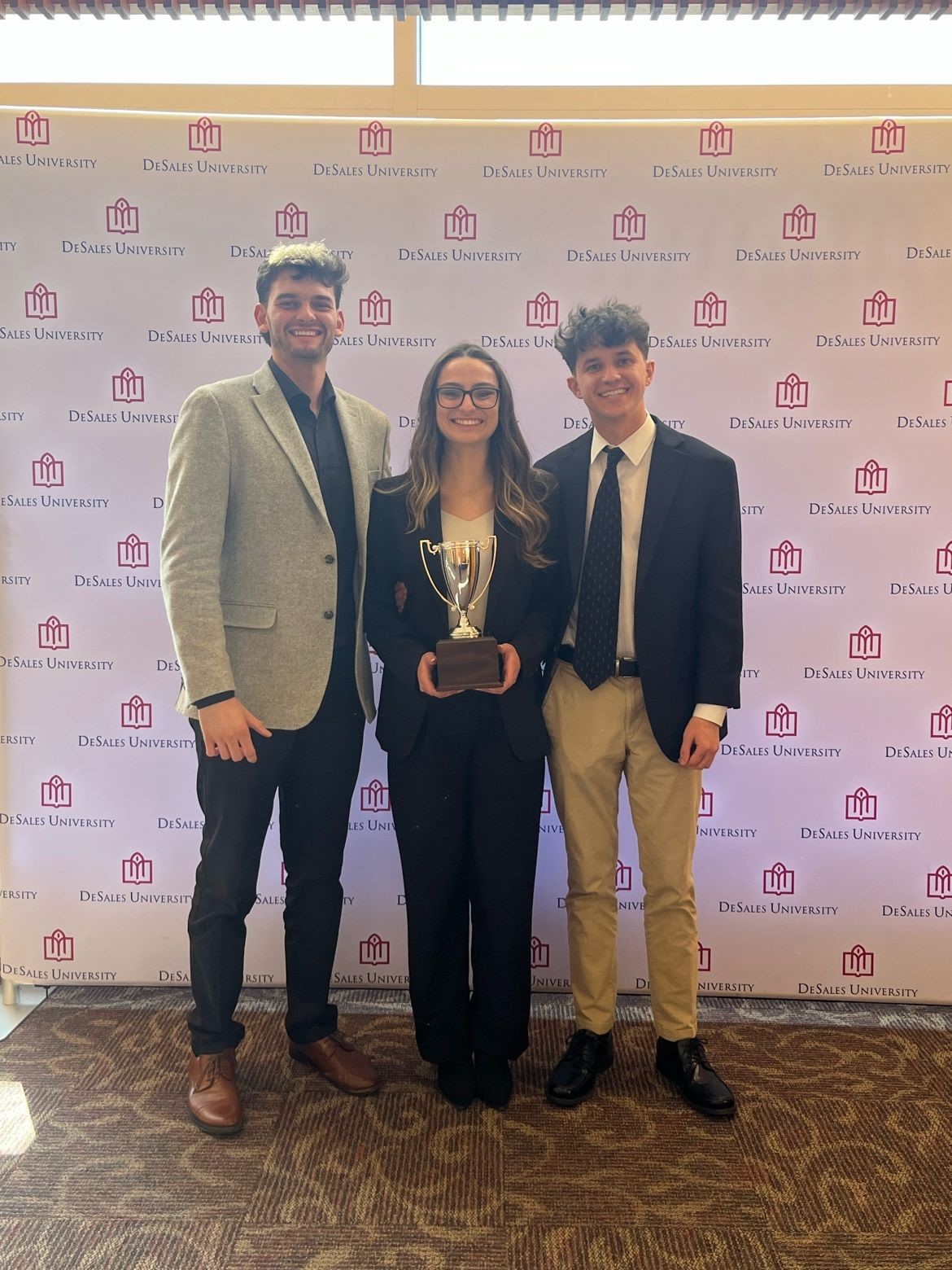 Three students, 2 male and one female, pose with a 2nd place award for the Spring ’24 Council for Retail and Sales Case Study Competition.
