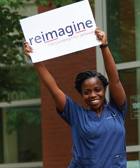 Thomas Jefferson University College of Nursing Student holding a reimagine campaign sign.