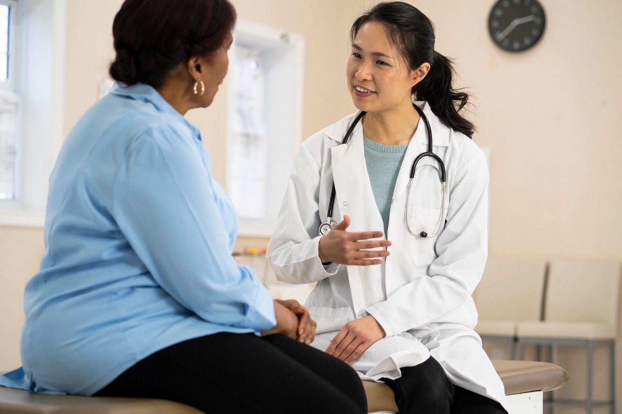 A senior woman of african descent listens to her doctor explain the outcome of her most recent tests.Her doctor is smiling as she gives her good news.