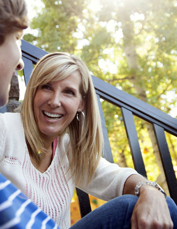 Woman sitting on a staircase and smiling at a person sitting next to them