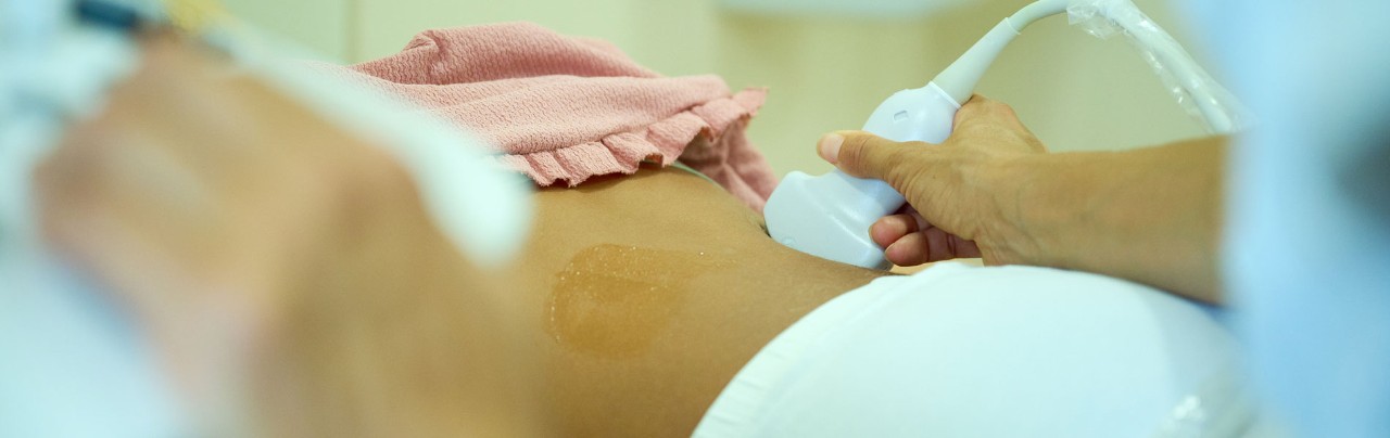 Pediatric ultrasound scan. Child ultrasound. Pediatrician scanning kidneys. Close up of doctor making kidneys sonogram for teen. Ultrasound examination of organs in clinic. Modern medical equipment.