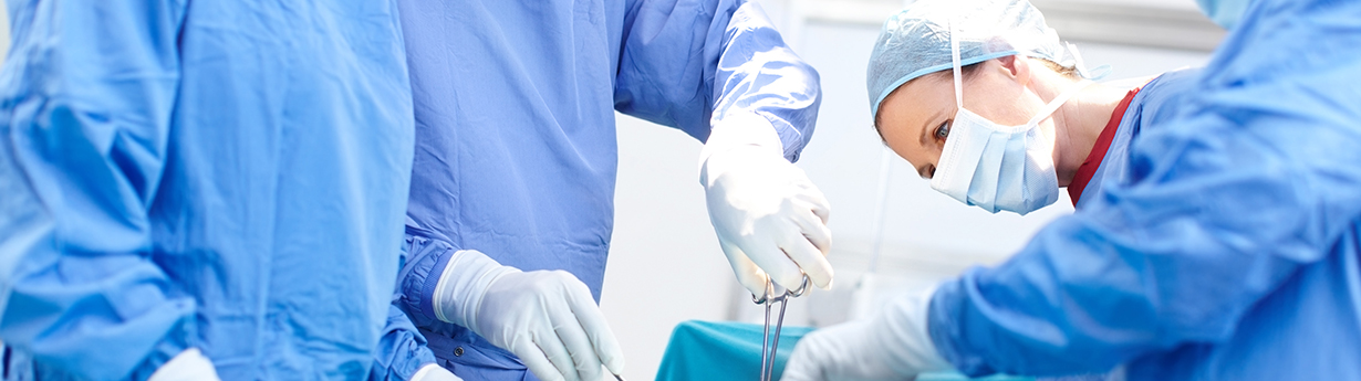 148442975 Profile shot of surgeons working together wearing scrubs in an operating room