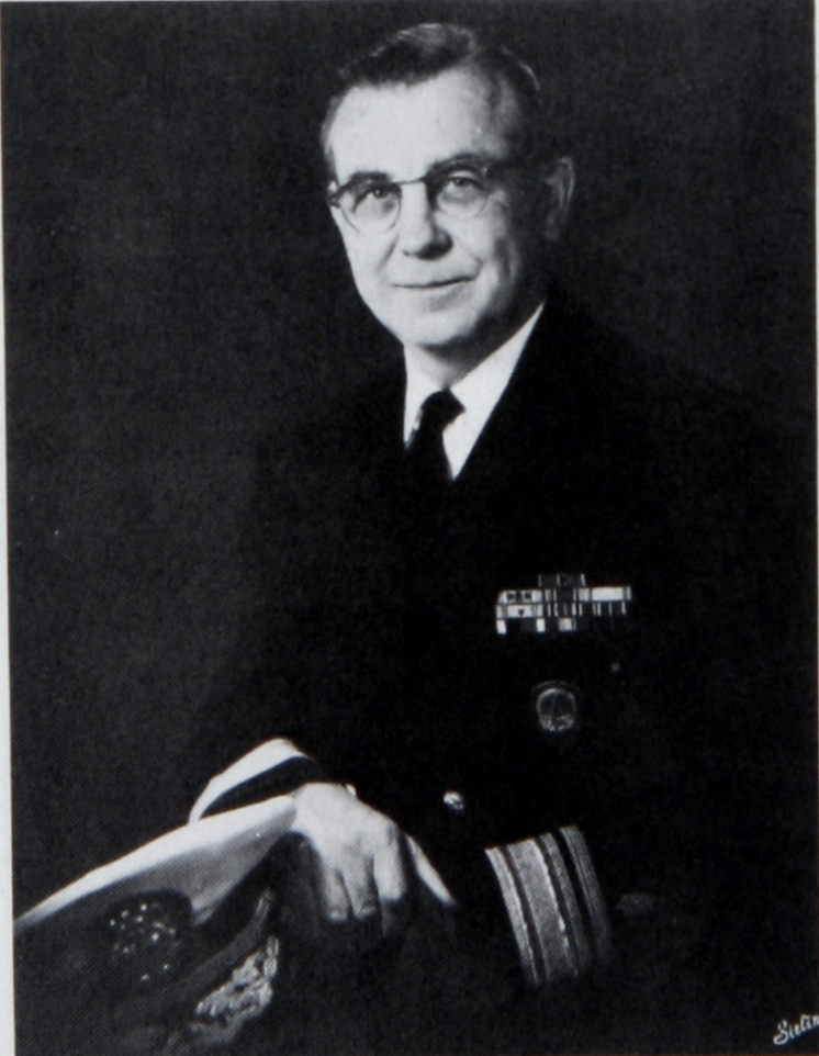 This image shows a black and white portrait photograph of Rear Admiral Cecil Coggins.