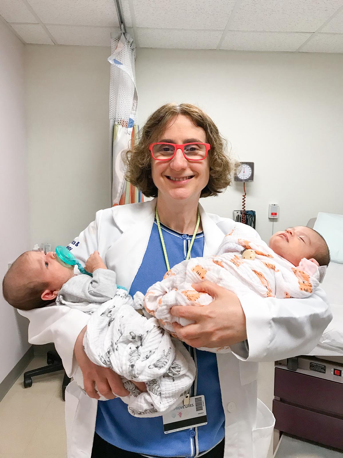 This image shows Huda Al-Kouatly, MD holding two newborn babies.