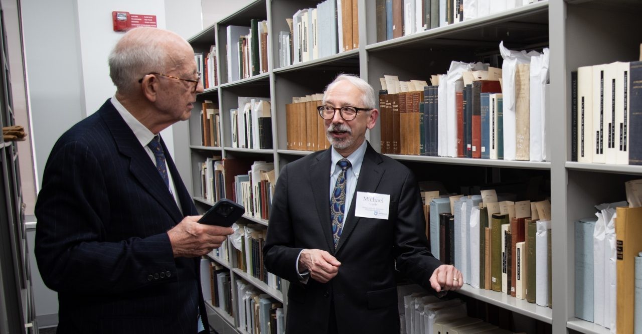 This image shows Dr. Elliot J. Rayfield, Class of 1967 (left), and Jefferson Archivist Michael Angelo (right), looking at rare books.