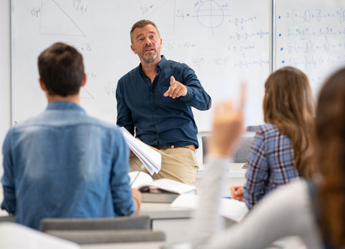 Student raising hand in classroom at the high school