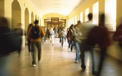 Blurred shot of high school students walking up the strs between classes in a busy school building, 