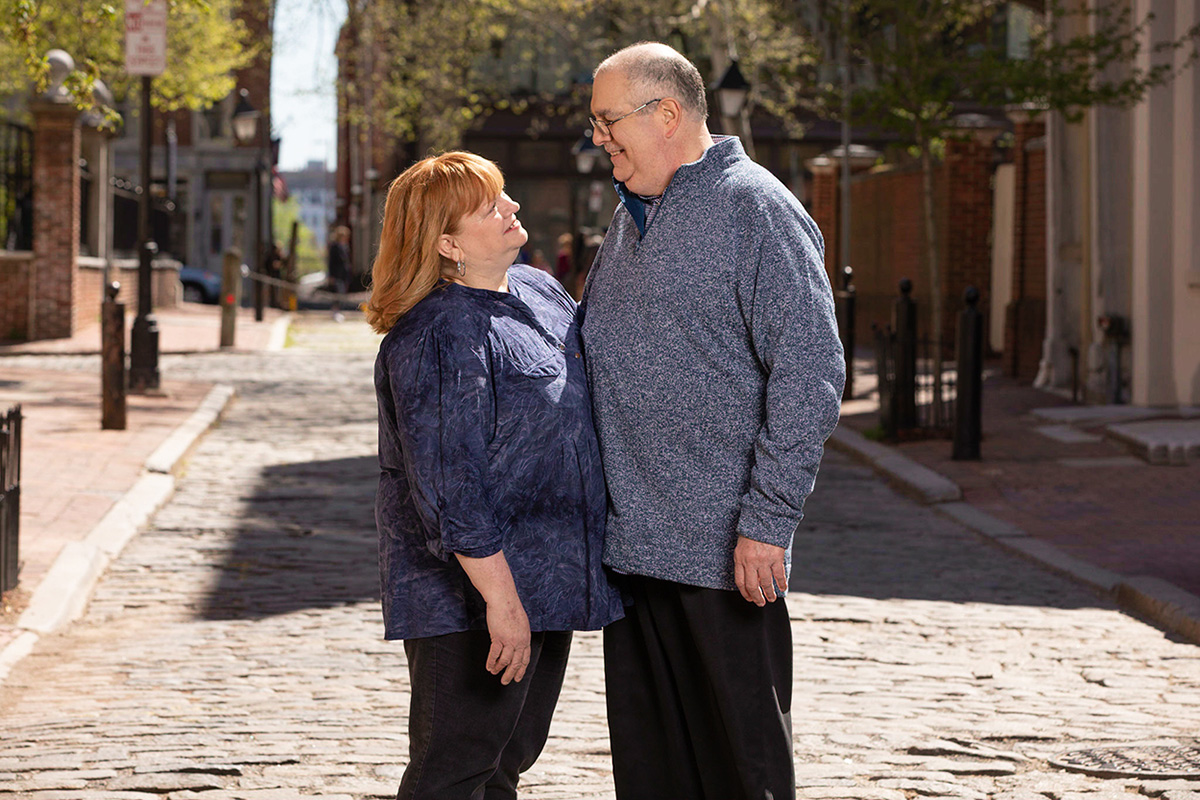 Andrew with his wife walking outdoors.