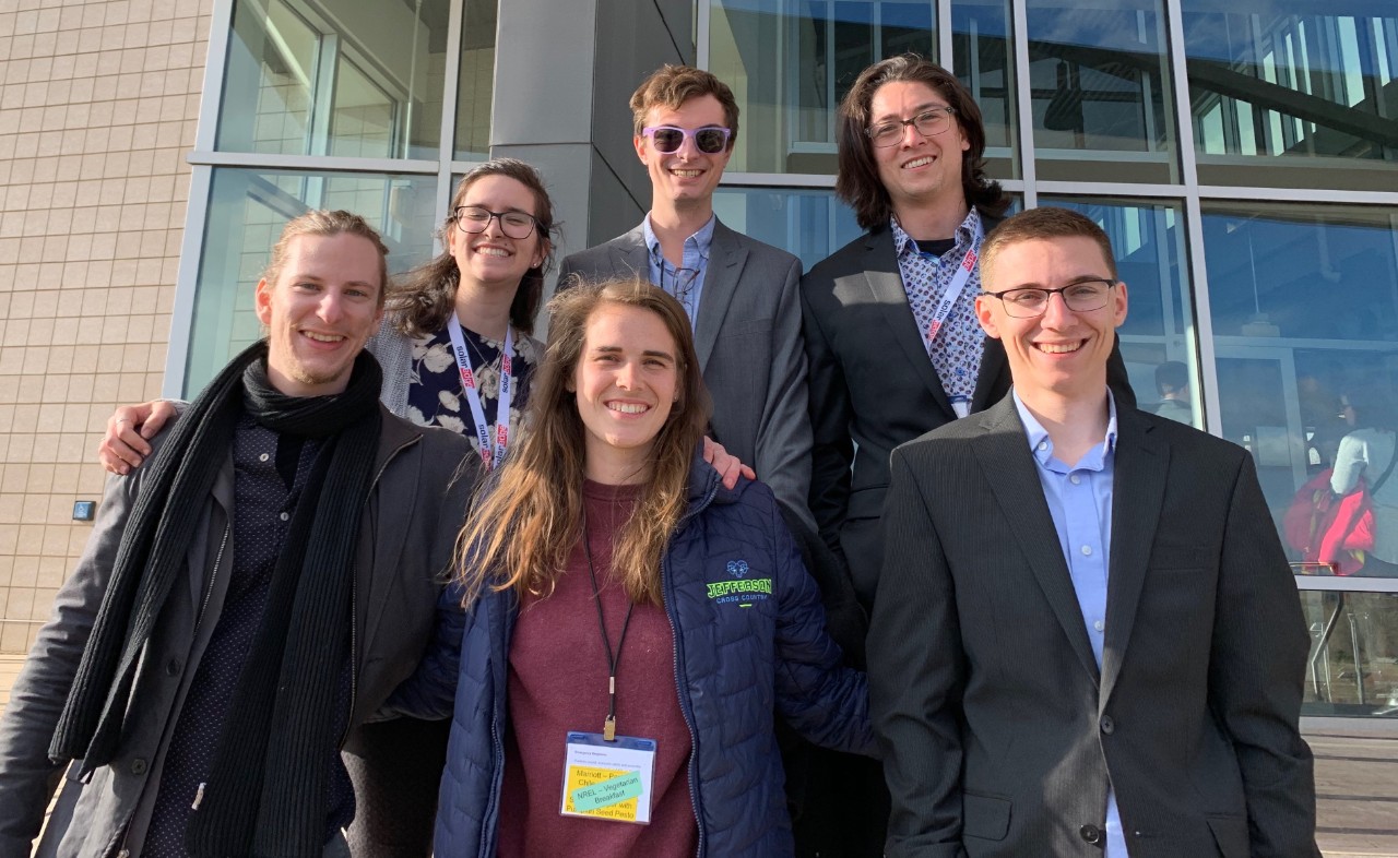 Six students stand in front of a building.