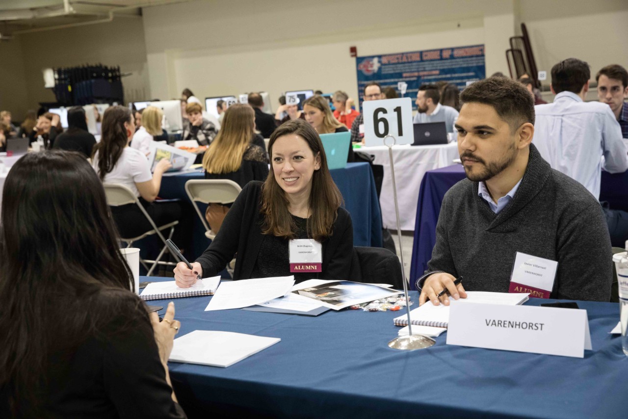 Two Jefferson alumni interview a student at a table.
