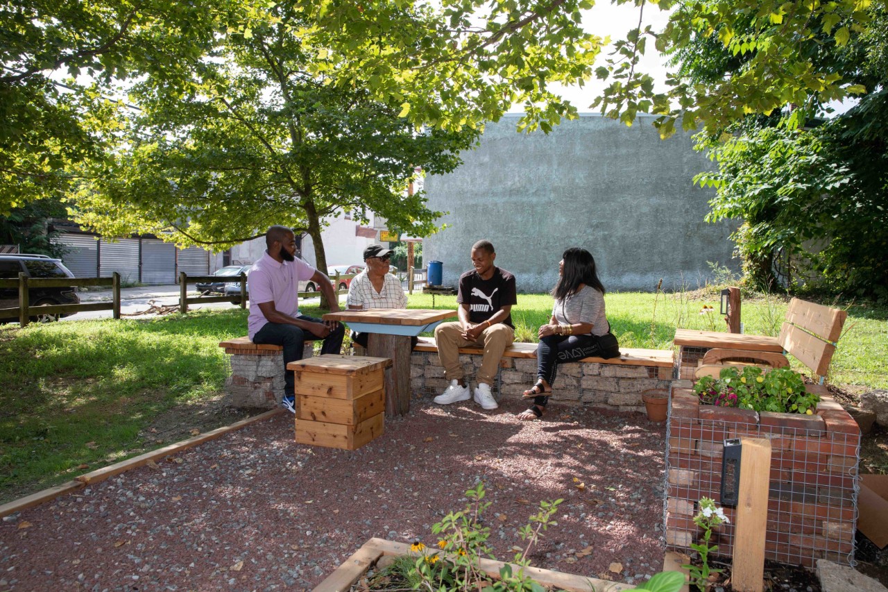 Four people sitting on benches talking to each other