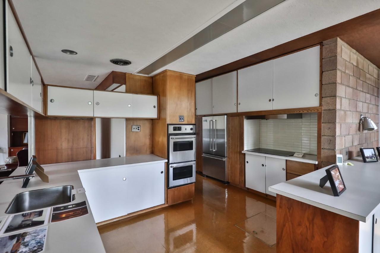 The kitchen—rehabilitated with modern appliances—still shows original finishes and hardware, such as the stove exhaust from 1958.
