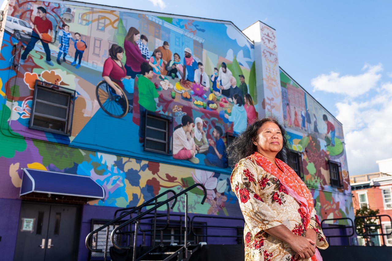 Faculty member stands in front of her mural