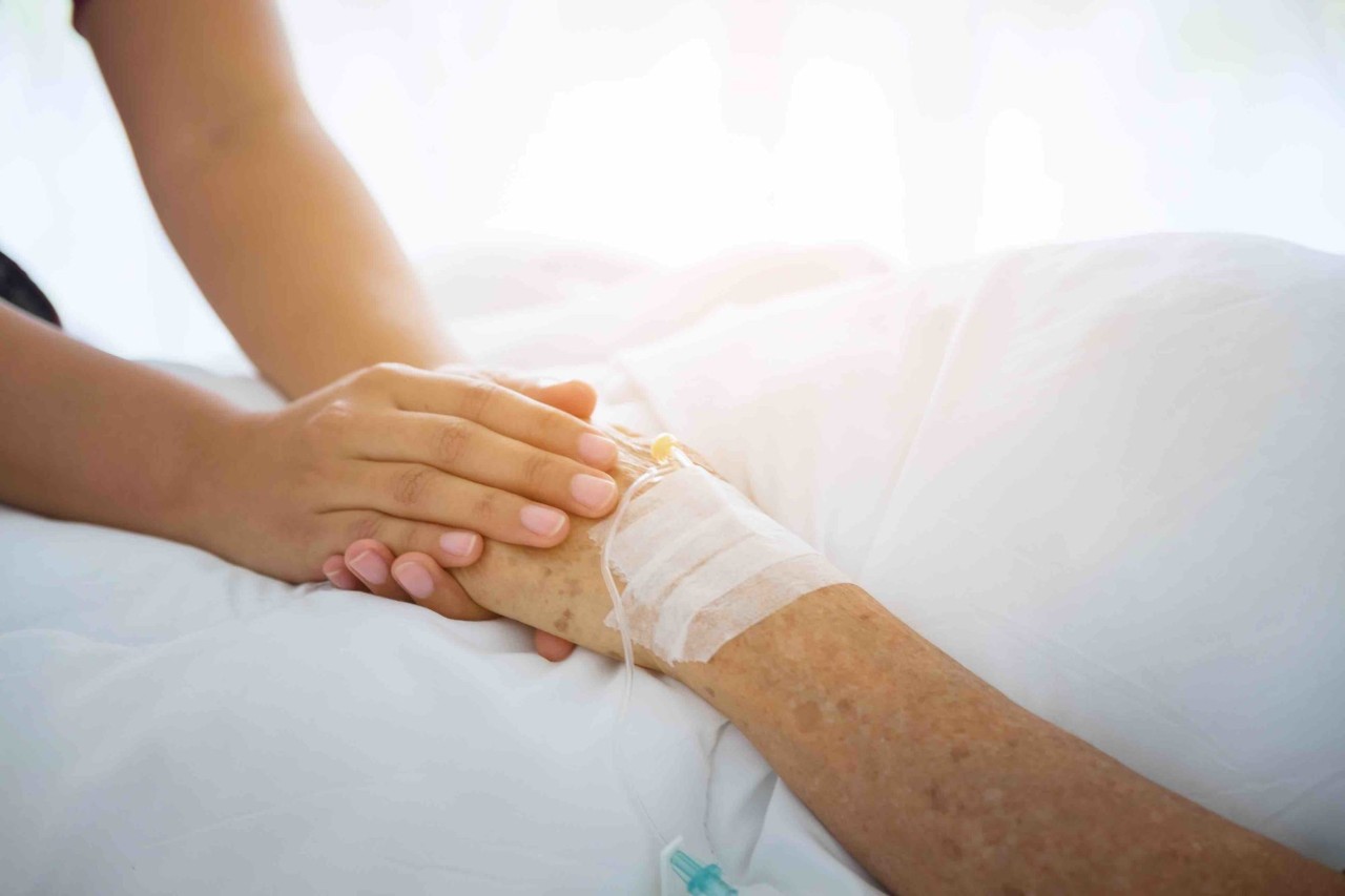A person holding a senior's hand