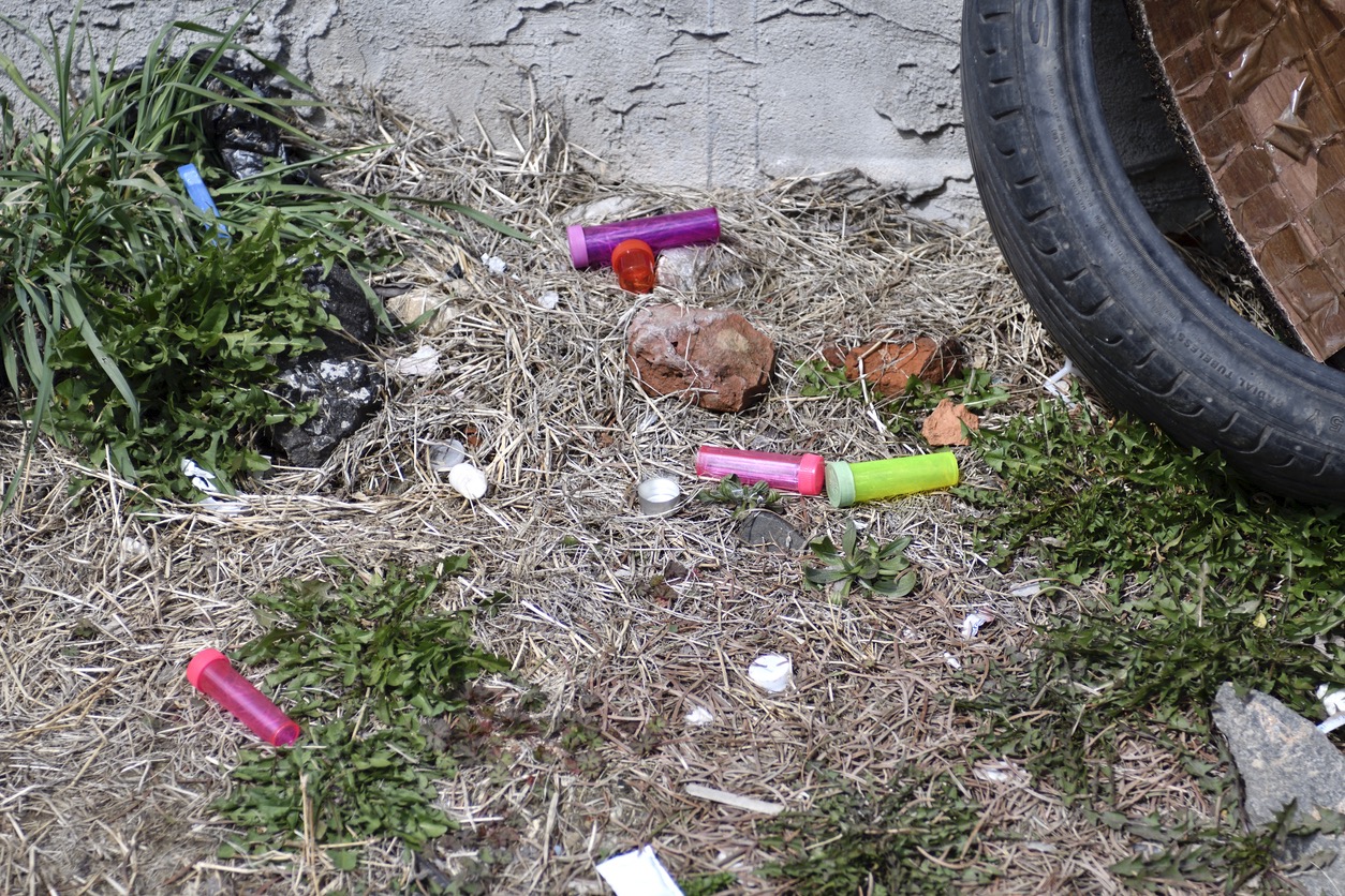Drug paraphernalia litter the ground.