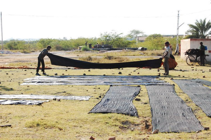 Two people with working with textiles in a field.