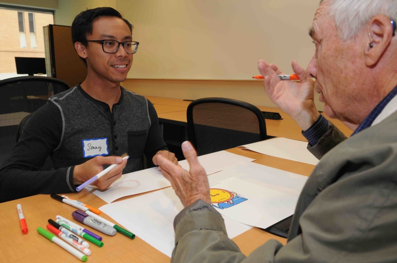 Bill sitting at a table with a student