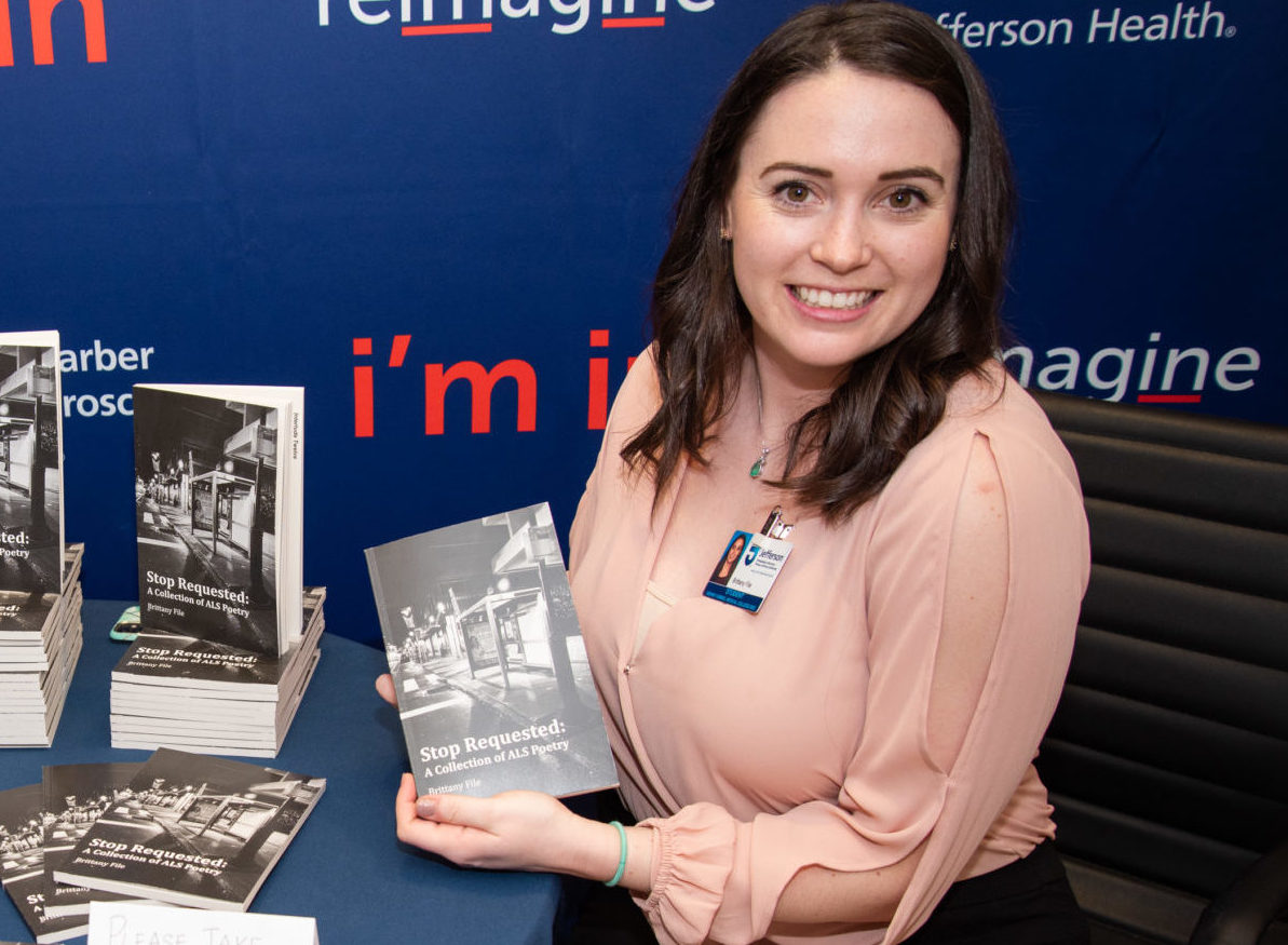 Brittany File holds a book of her poetry