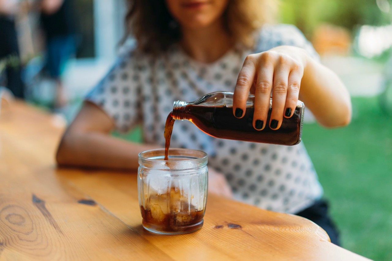 A woman pouring a cup of cold-brew coffee Cold brew coffee