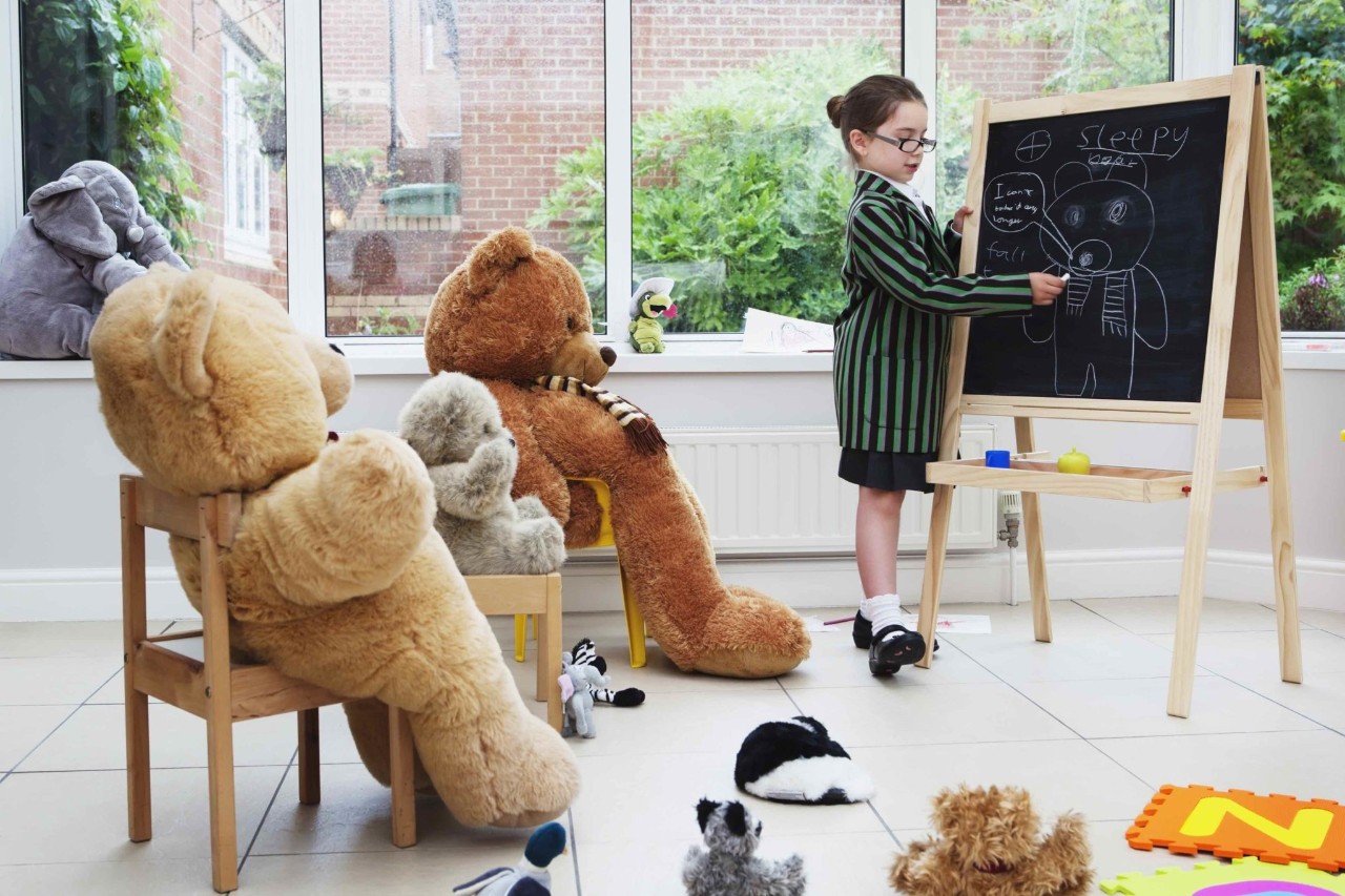 Child play teaching her stuffed animals