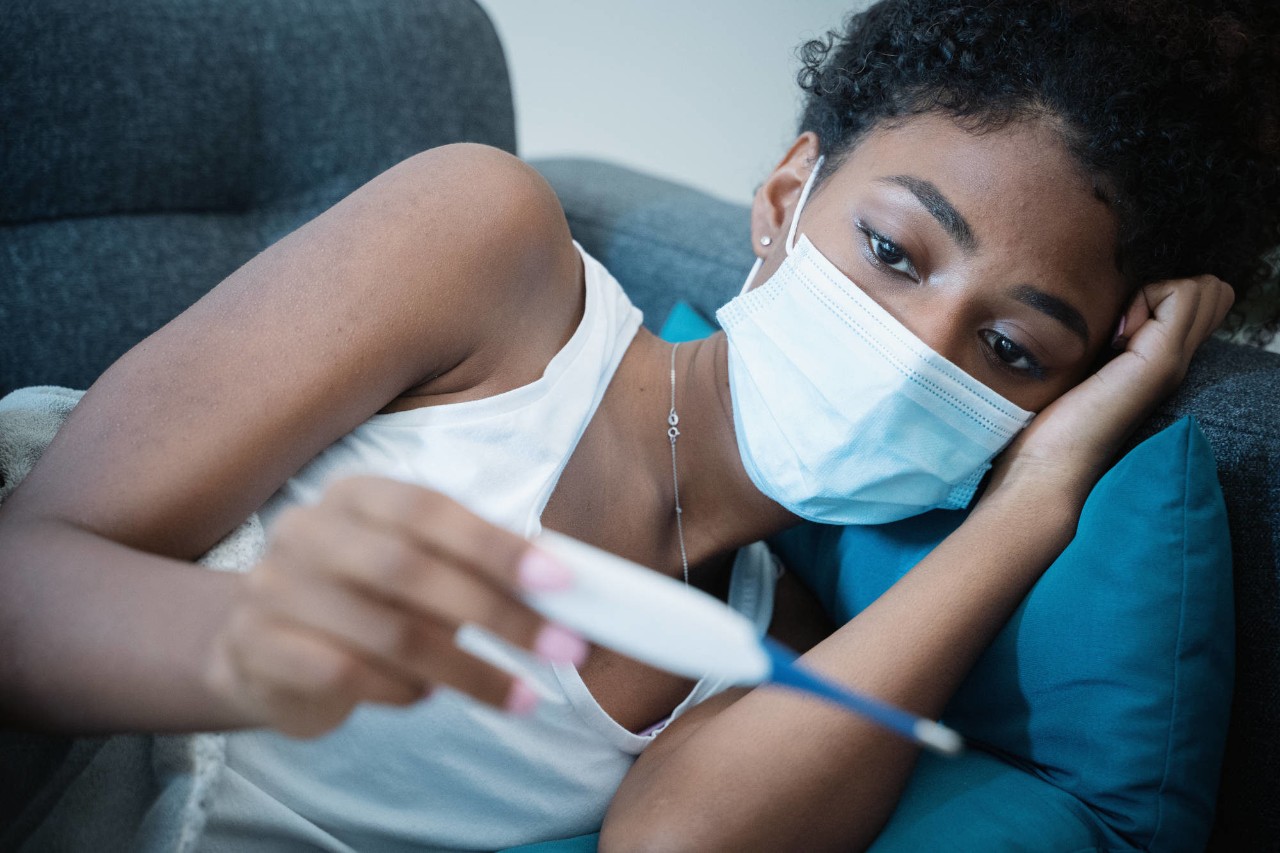 black woman suffering from COVID-19 on the sofa at home