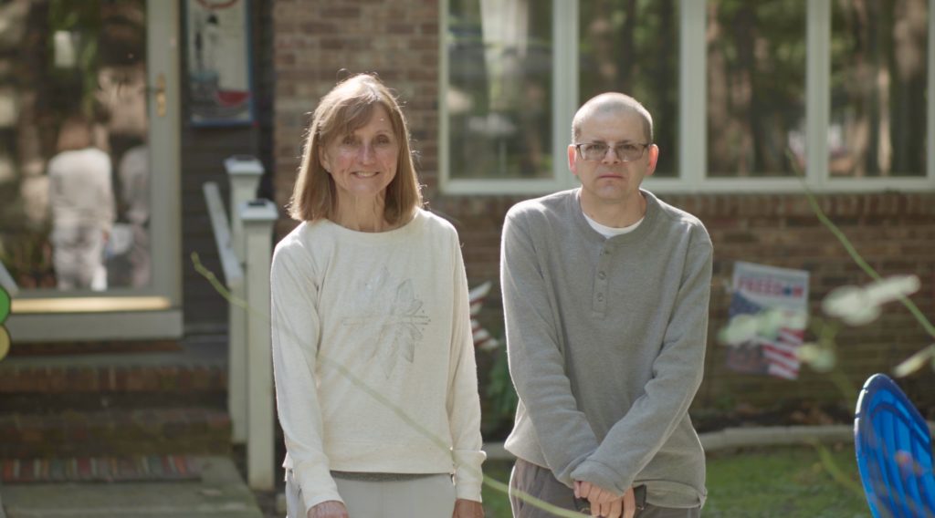 Holly and Aaron standing and in front of their house