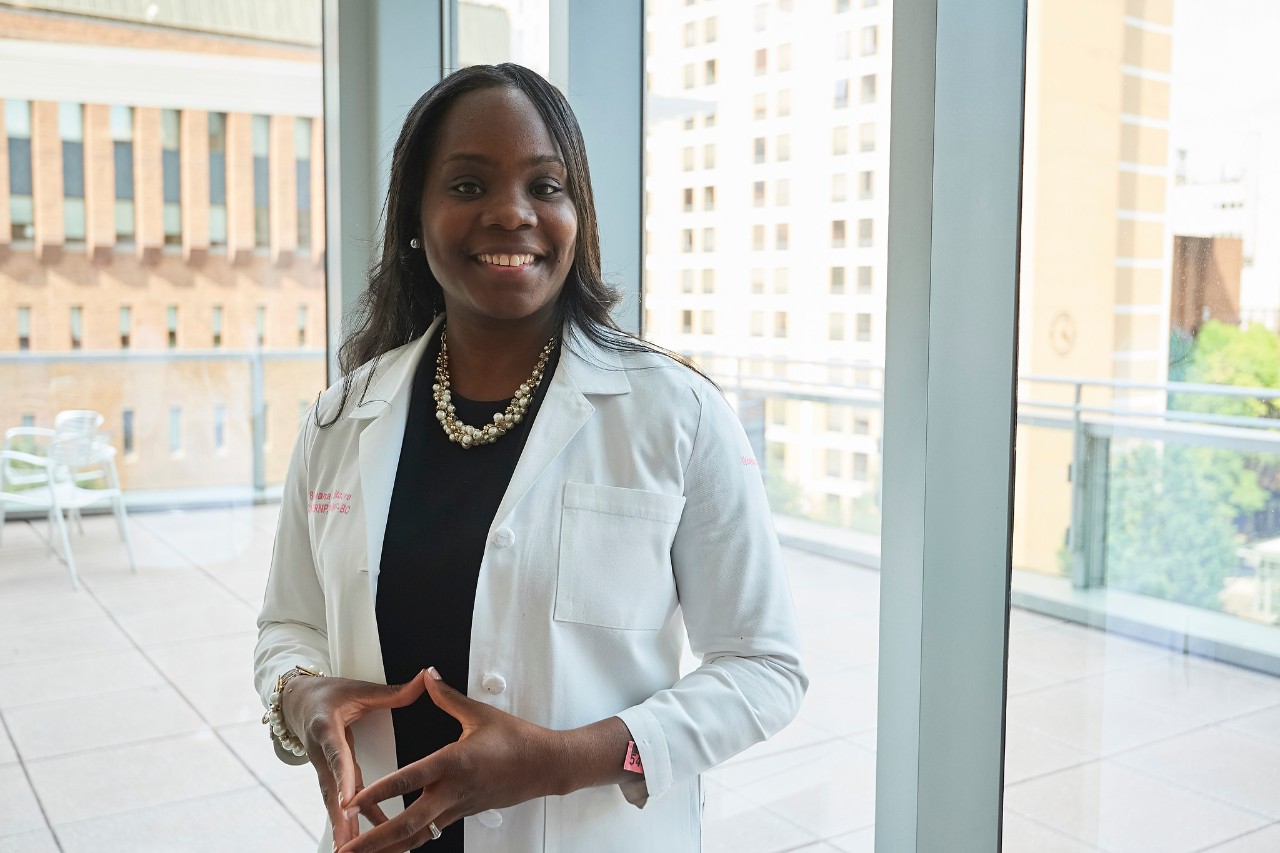 black woman in doctor's coat standing in front of window
