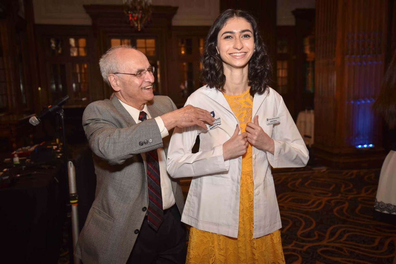 Jamie Nassur putting on white coat