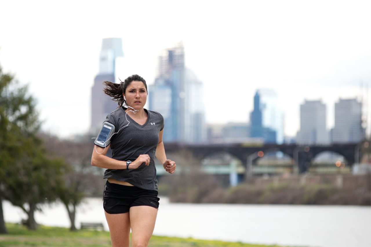 Woman running Philadelphia Philadelphia, PA, USA - April 4, 2017; Cherry blossoms on the Schuylkill River banks in full bloom are an attraction to many, including joggers and cyclist, enjoying the early spring weather, in the Fairmount Park section of Philadelphia, Pennsylvania.