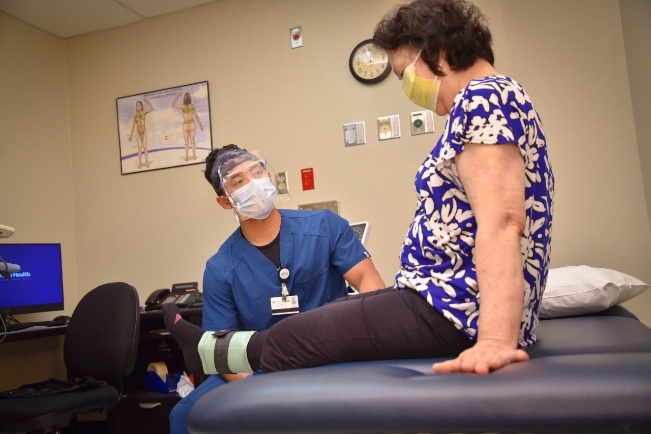 Physical therapy student Putira Peter Siv working with a patient