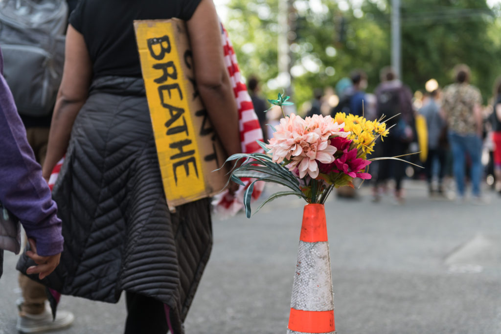 Woman walking with a &quot;I can't breathe&quot; sign