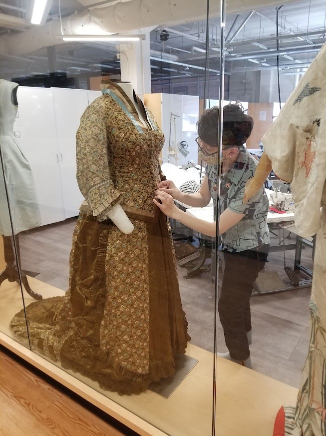 Jade Papa works on the Behind the Seams exhibit