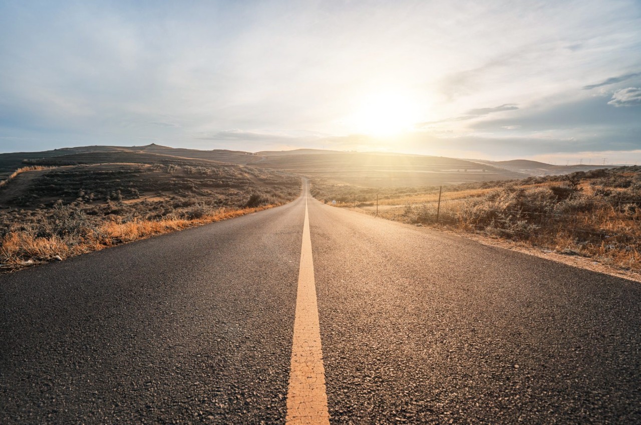 Highway scene with rising sun in the distance