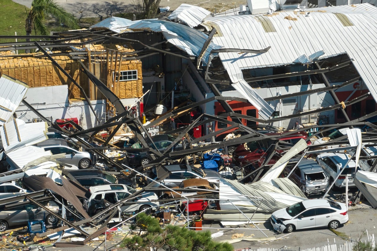 Hurricane Ian destroyed industrial building with damaged cars under ruins in Florida