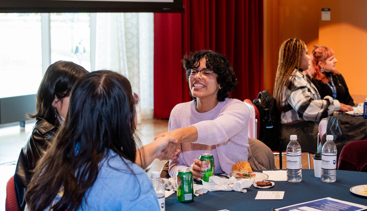 Students shaking hands at first-generation lunch
