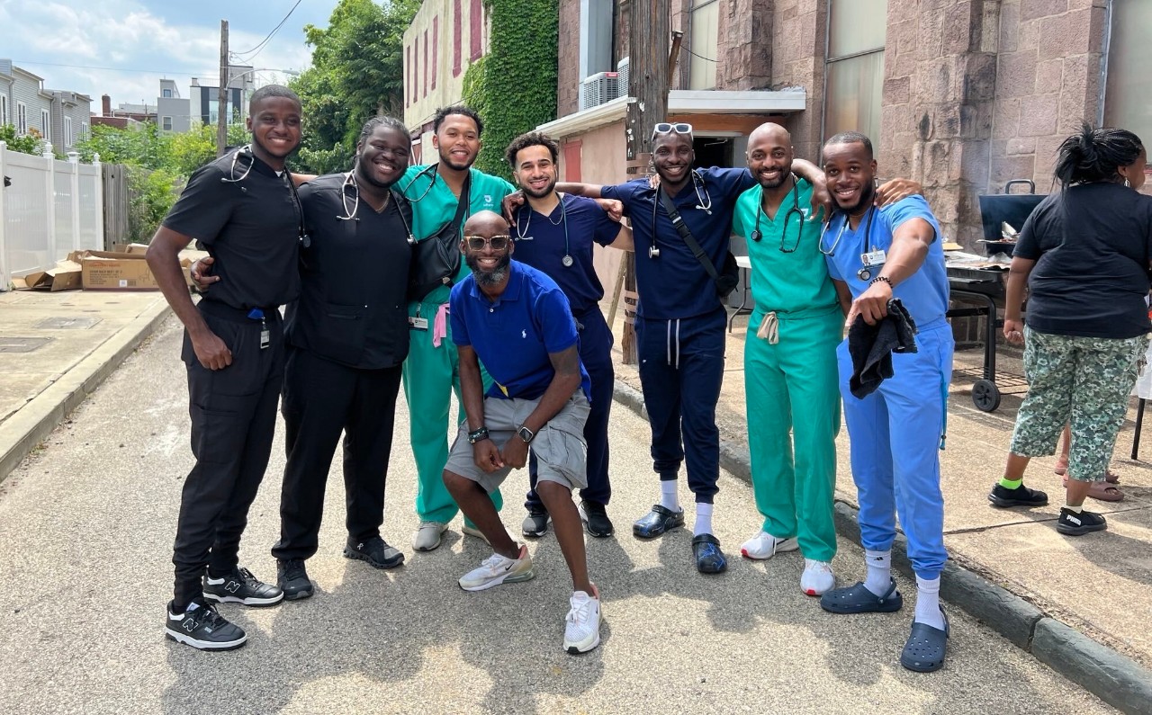 Group photo of black men in white coats