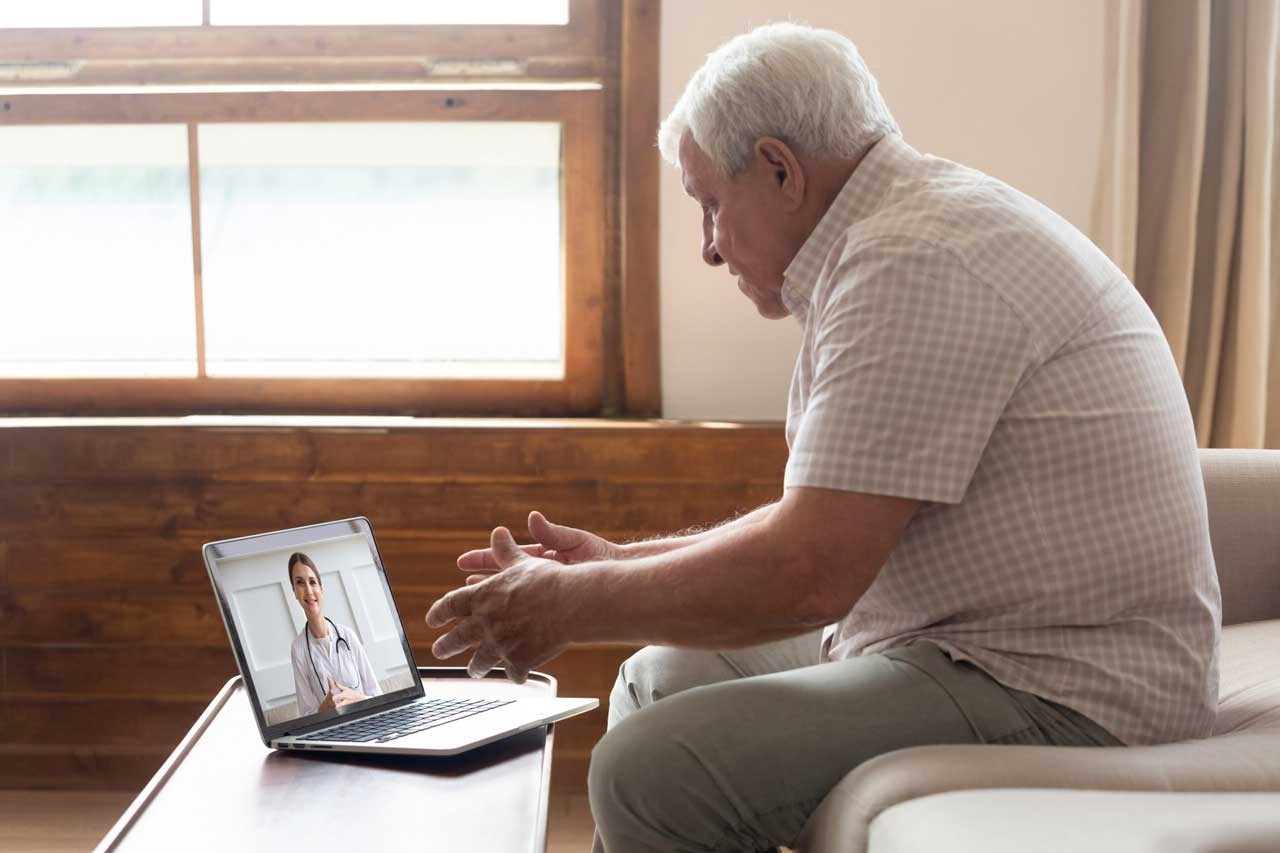 Elderly man make distant video call communicating with doctor online