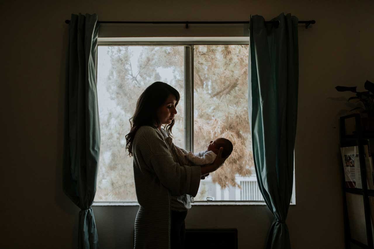 Mother holding her baby indoors