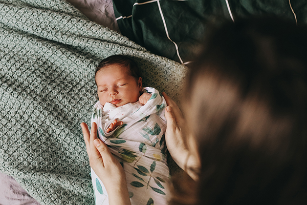 young mother swaddling a newborn baby