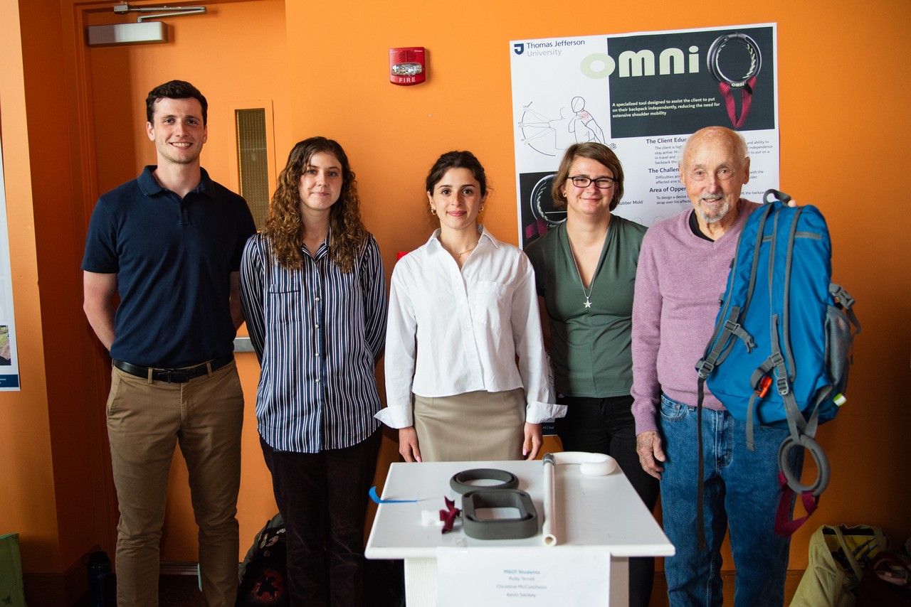 Students designed a tool to help client educator Robert Rabinowitz put on his backpack after he retore a surgically repaired rotator cuff.