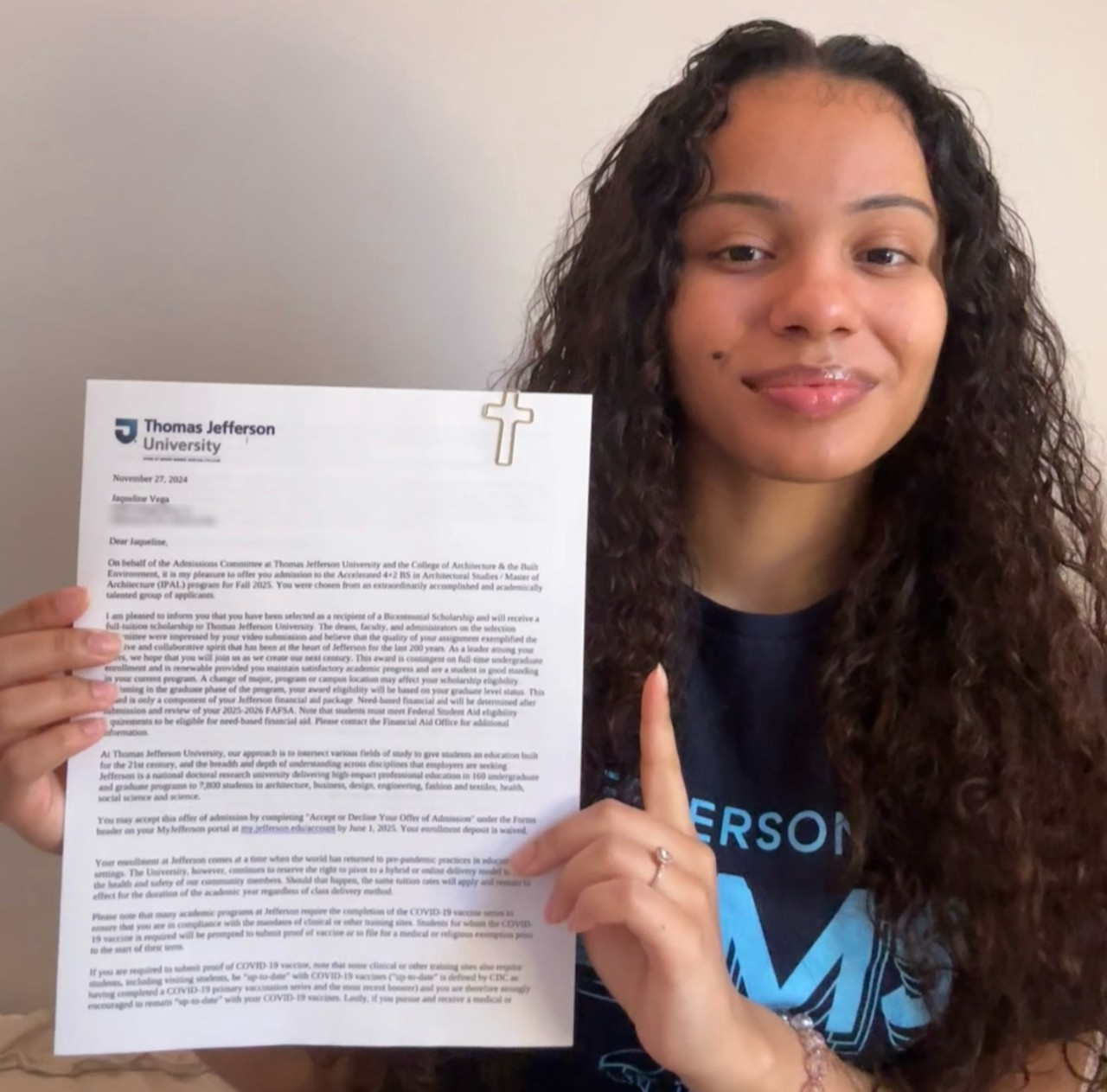 Jaqueline Vega holding up her acceptance letter to Jefferson.